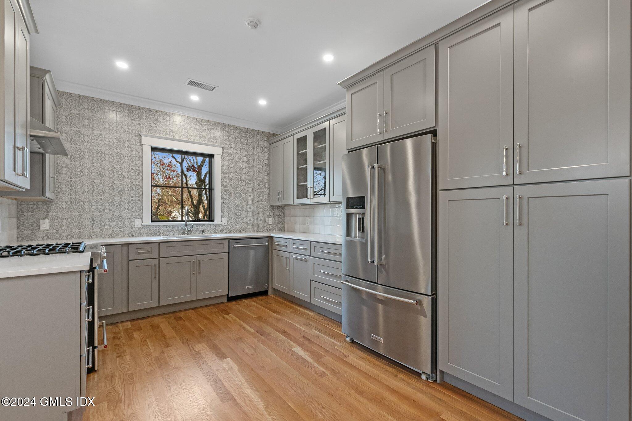 96 Weaver Street, Unit A Greenwich, CT 06831 - Photo 10 of 26 a kitchen with granite countertop stainless steel appliances a refrigerator counter space and wooden floor