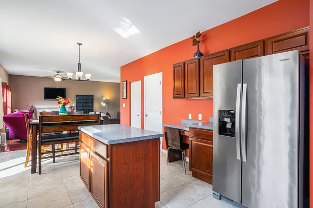 a kitchen with kitchen island a counter top space appliances and a chandelier