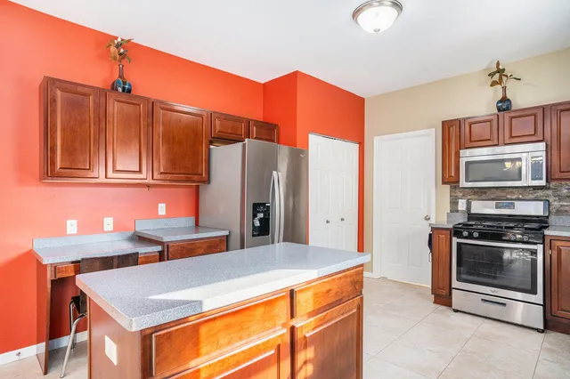 a kitchen with stainless steel appliances a stove refrigerator and microwave