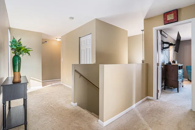 a view of a hallway to rooms and livingroom