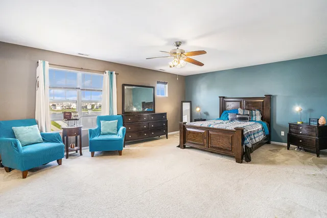 a spacious bedroom with furniture and a large window