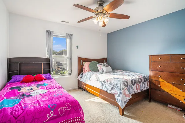 a bedroom with a bed and dresser with window
