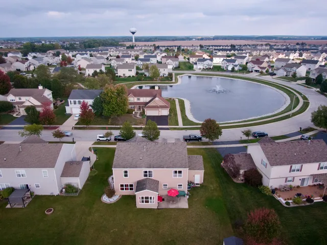 an aerial view of residential houses with outdoor space and parking