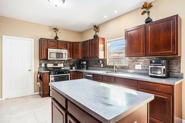 a kitchen with stainless steel appliances granite countertop a sink stove and refrigerator