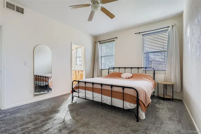 a spacious bedroom with a bed and a chandelier