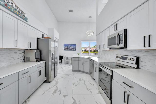 a kitchen with white cabinets and stainless steel appliances
