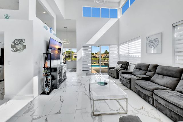 a living room with furniture kitchen view and a window