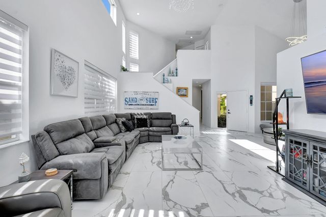 a living room with furniture a flat screen tv and a window