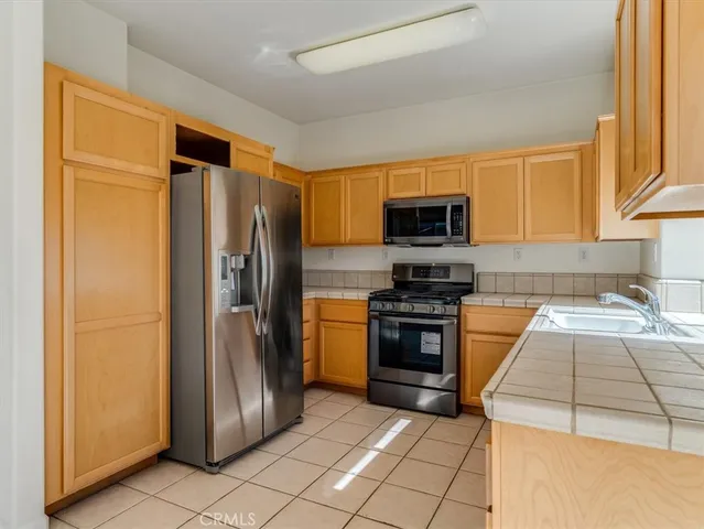 a kitchen with granite countertop a refrigerator and a sink
