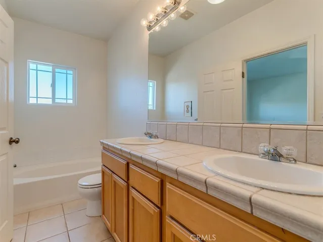 a bathroom with a granite countertop toilet a sink and a mirror