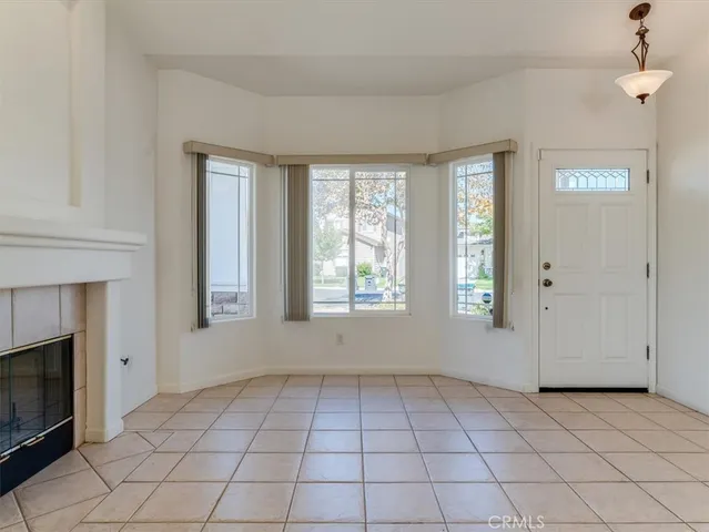 a view of an empty room with window and fire place