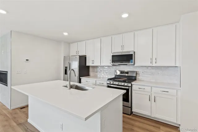 a kitchen with white cabinets stainless steel appliances and sink
