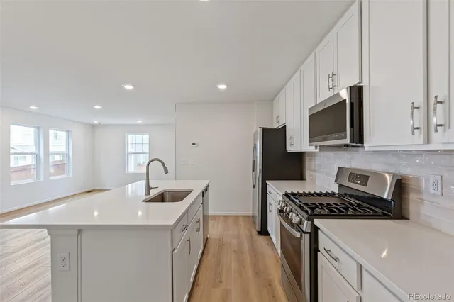a kitchen that has a sink and a stove top oven