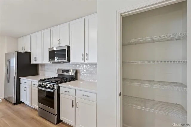 a kitchen with white cabinets and stainless steel appliances