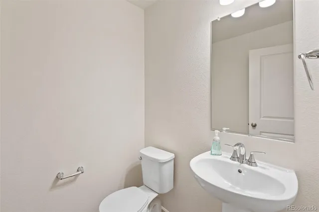 a bathroom with a sink mirror and toilet