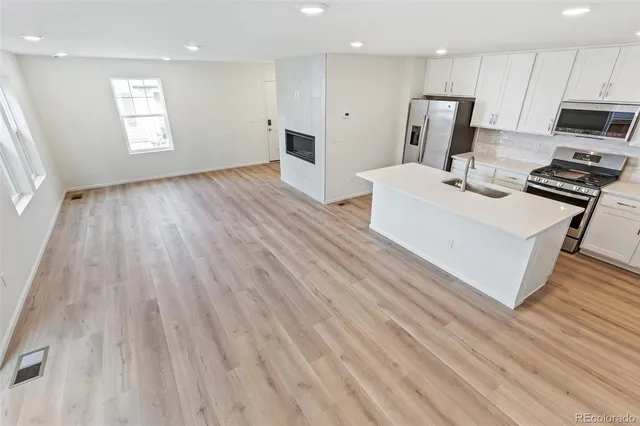 a kitchen with stainless steel appliances a refrigerator sink and microwave