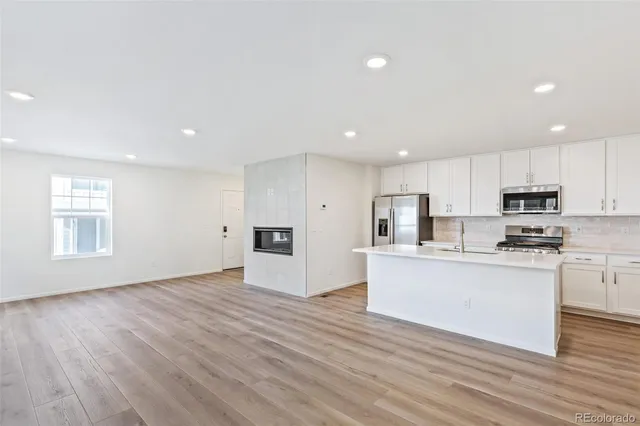 a kitchen with stainless steel appliances a refrigerator sink and microwave