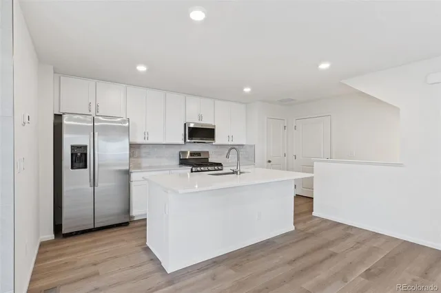 a view of kitchen with stainless steel appliances a refrigerator and a stove top oven