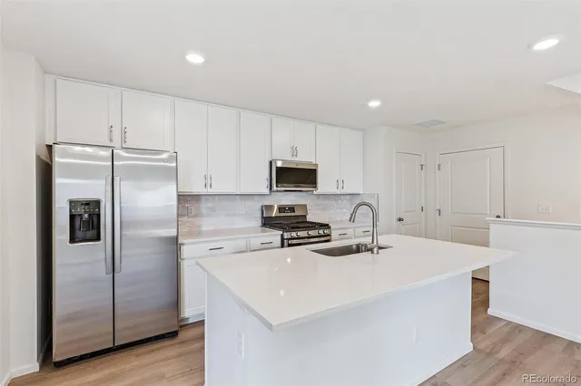 a kitchen with stainless steel appliances a refrigerator sink and microwave
