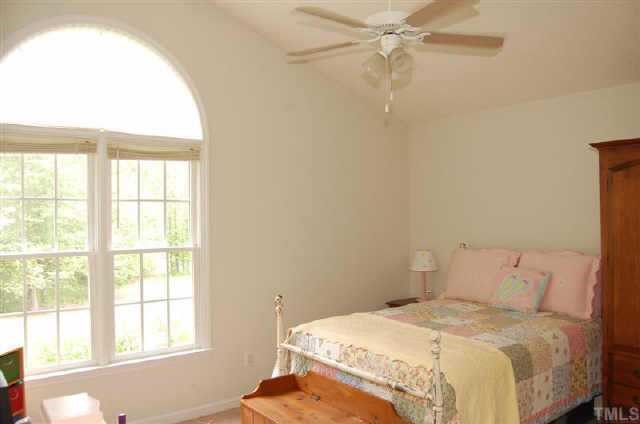This gorgeous bedroom is highlighted by a vaulted ceiling and paladium window.  Notice the view from the window....trees and nature.  This view is typical of what you see from most of the windows in this home.