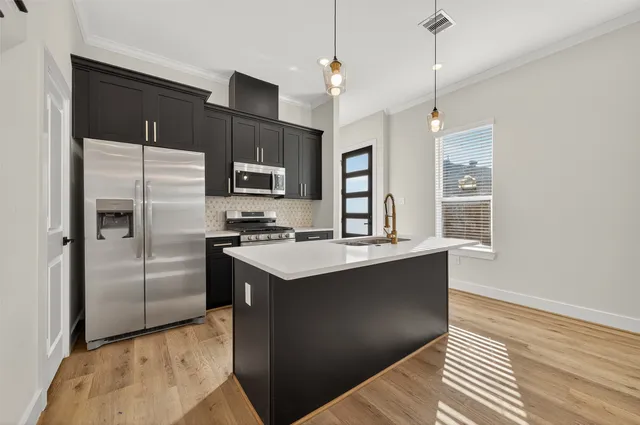 a kitchen that has a sink a stove and a large window