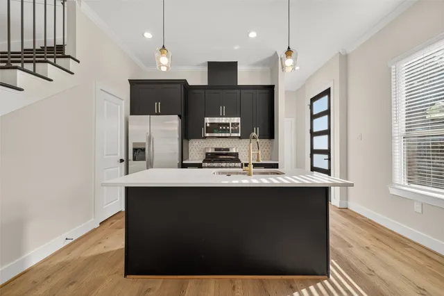 a kitchen with kitchen island a sink appliances and cabinets