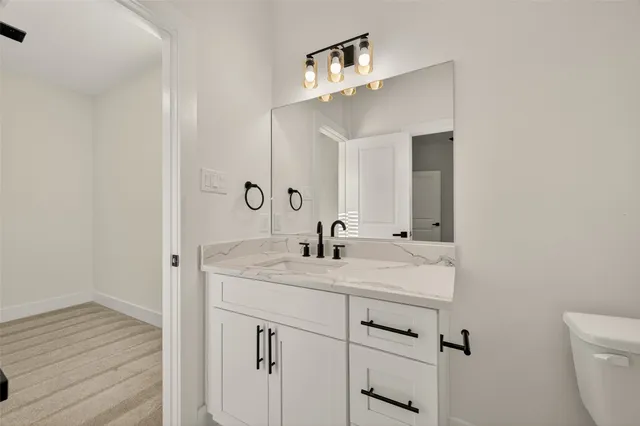 a bathroom with a toilet a sink and mirror