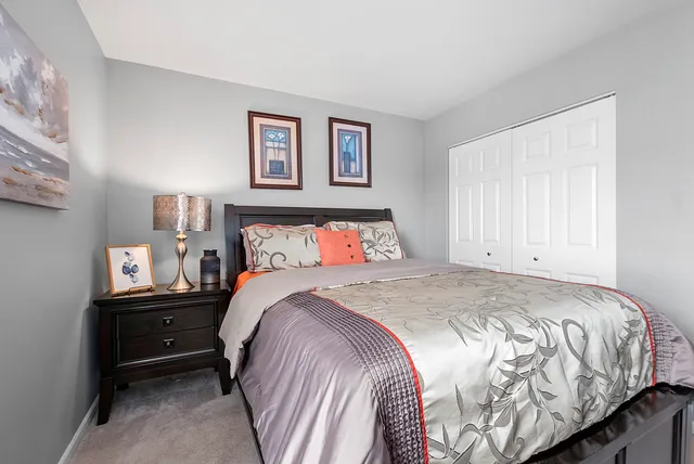 a bedroom with a bed and a lamp on dresser