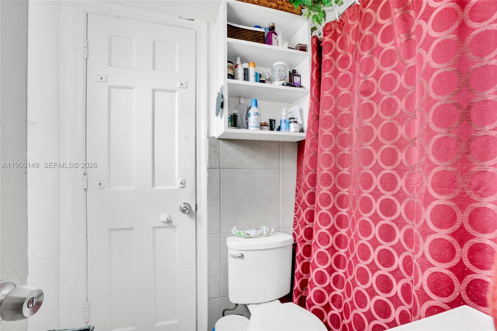 5955 Southwest 4th Street Miami, FL 33144 - Photo 9 of 18 a white toilet sitting next to a shower curtain