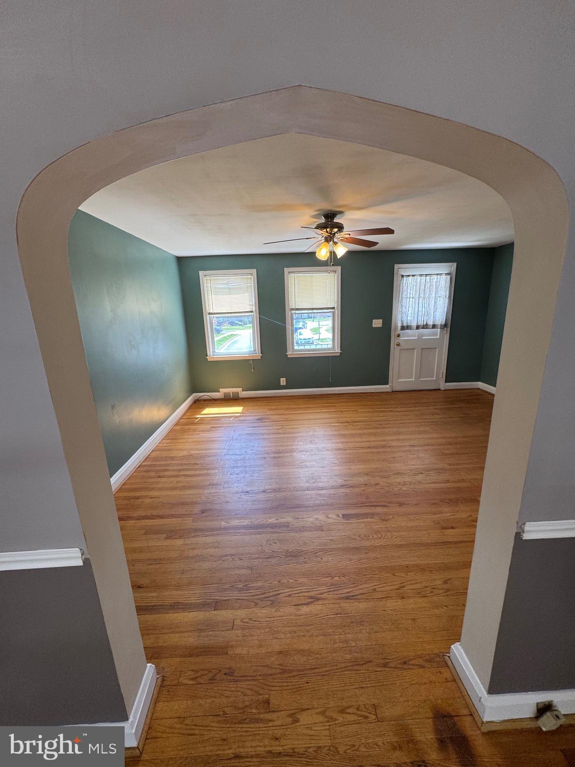 1052 Downton Road Baltimore, MD 21227 - Photo 11 of 55 a view of an empty room with wooden floor and a window