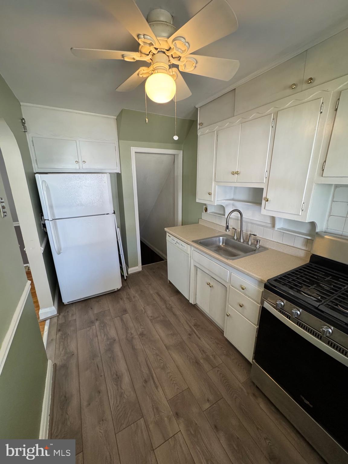 1052 Downton Road Baltimore, MD 21227 - Photo 15 of 55 a kitchen with a sink and wooden floor