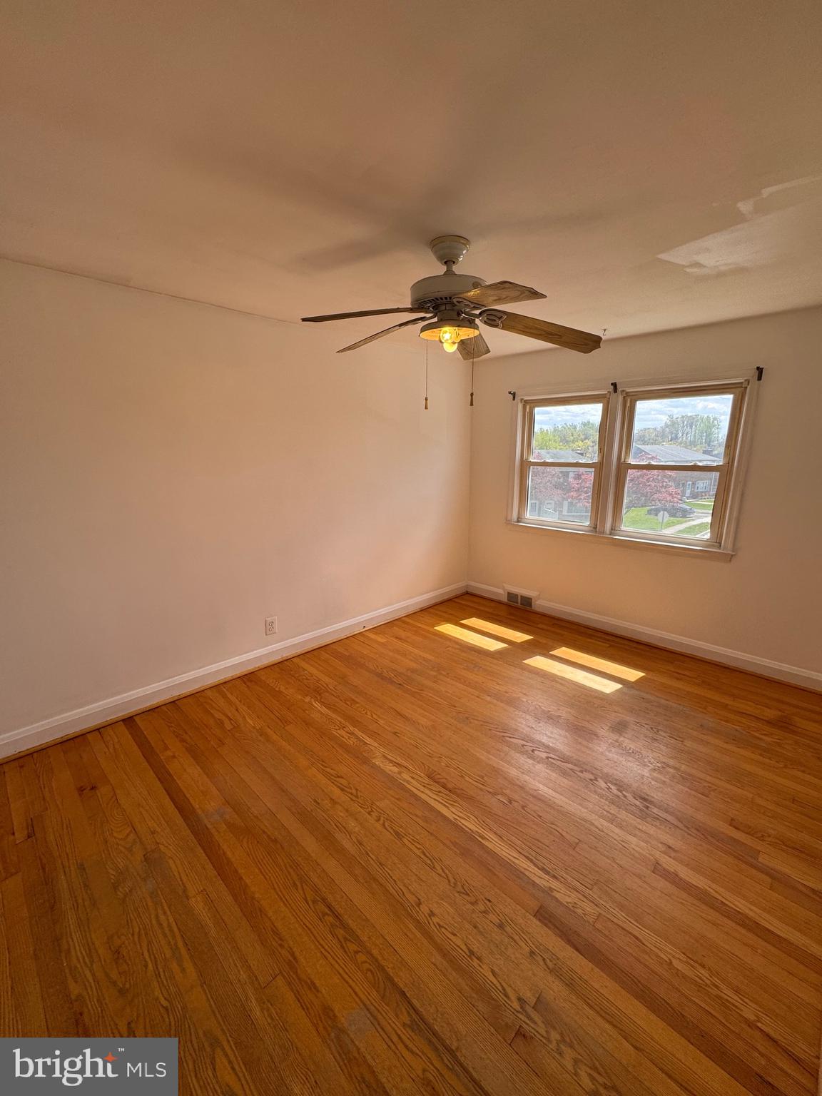 1052 Downton Road Baltimore, MD 21227 - Photo 24 of 55 an empty room with wooden floor and windows