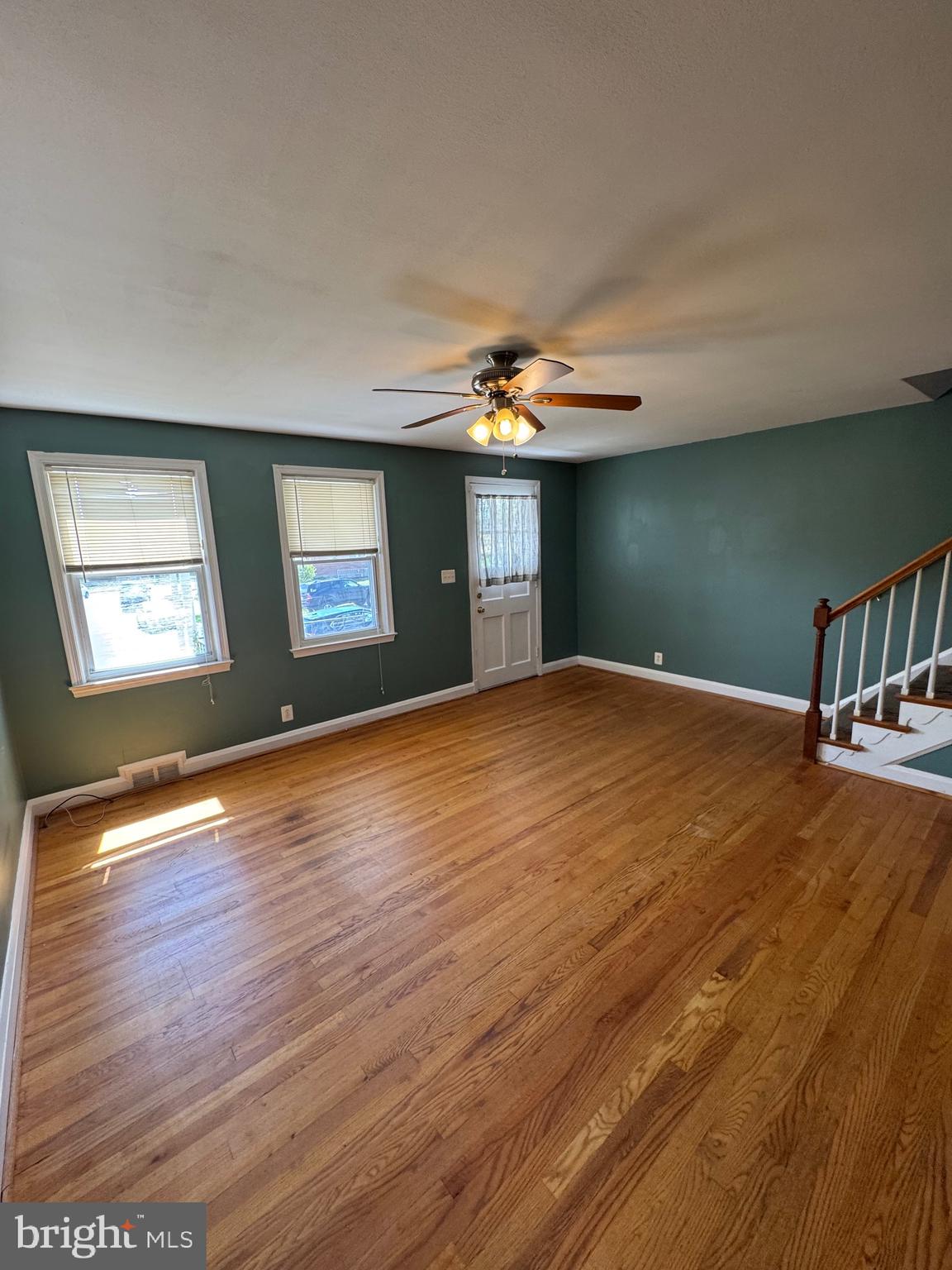 1052 Downton Road Baltimore, MD 21227 - Photo 5 of 55 a view of an empty room with window and wooden floor