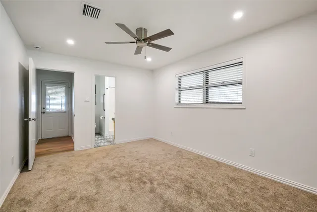 an empty room with fan and windows
