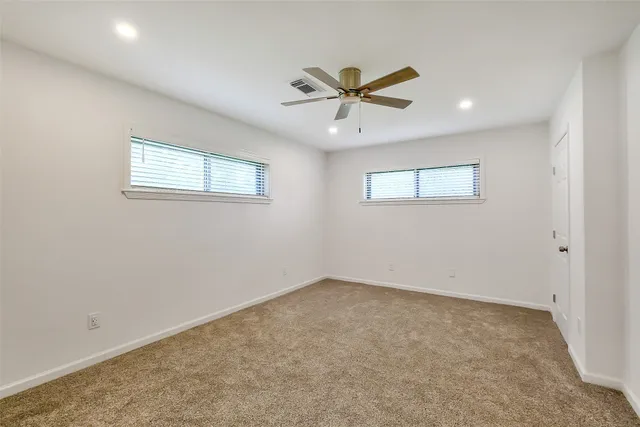 a view of a big room with wooden floor and windows
