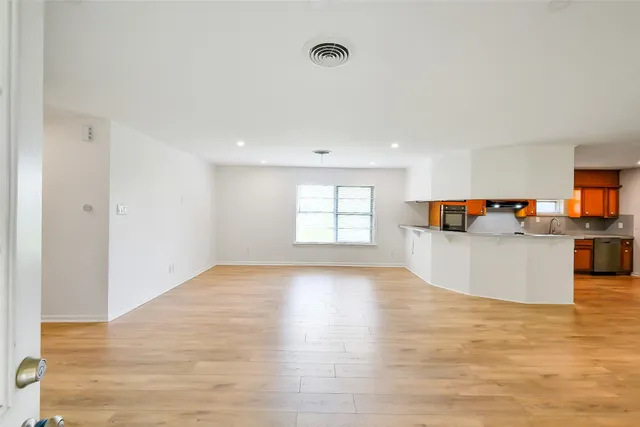 a view of empty room with wooden floor and fireplace
