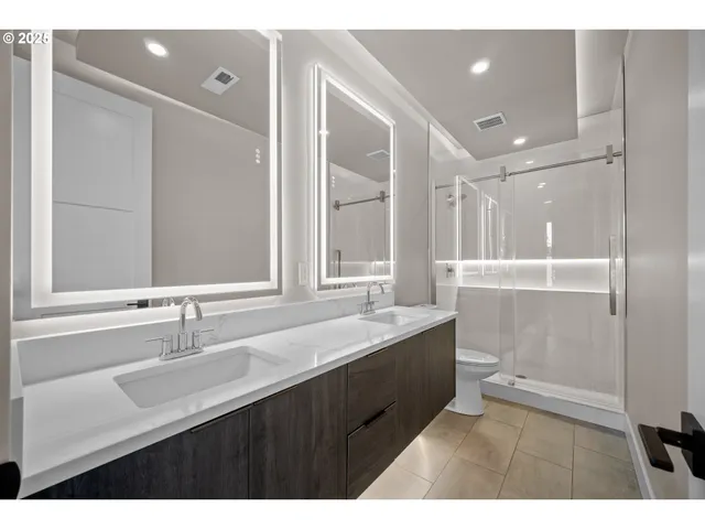 a bathroom with a sink double vanity granite tub and a mirror