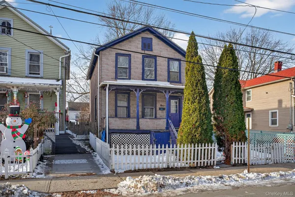 a view of a house with a small yard and wooden fence
