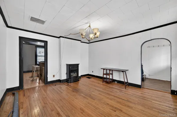 a view of empty room with wooden floor and fireplace