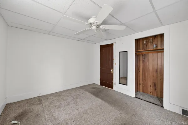 an empty room with windows and fan