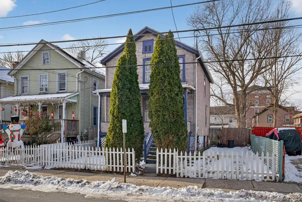 a view of a house with a small yard and wooden fence