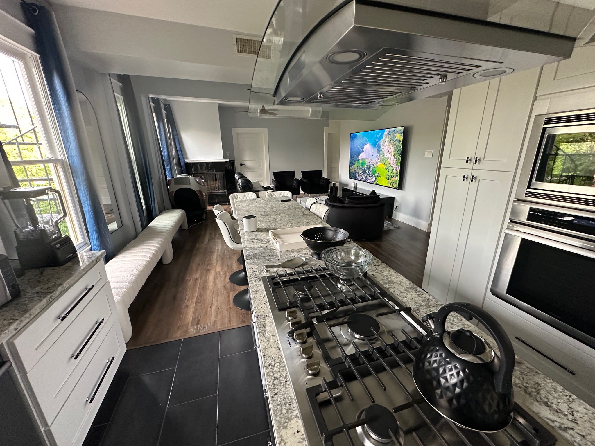 3210 Hampton Road, Unit A B C Austin, TX 78705 - Photo 23 of 42 Kitchen with exhaust hood, dark tile patterned floors, light stone counters, appliances with stainless steel finishes, and white cabinets