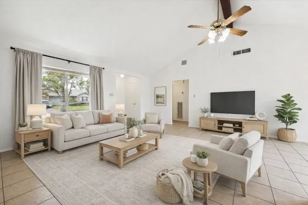 a living room with furniture ceiling fan and a window