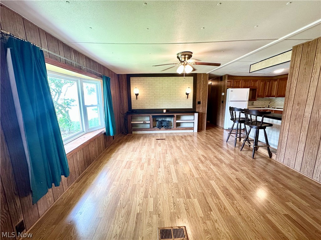 28 Richter Road Colliers, WV 26035 - Photo 16 of 38 Family room featuring an electric fireplace, ceiling fan, and hardwood floors