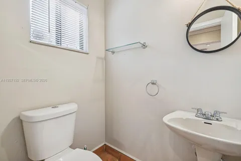 a bathroom with a toilet sink and mirror