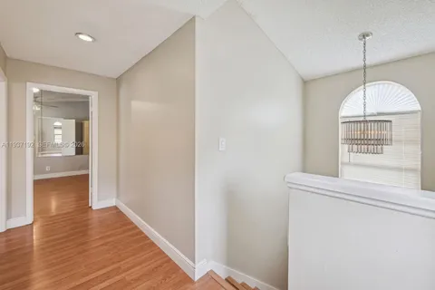 a view of a hallway with wooden floor and a window