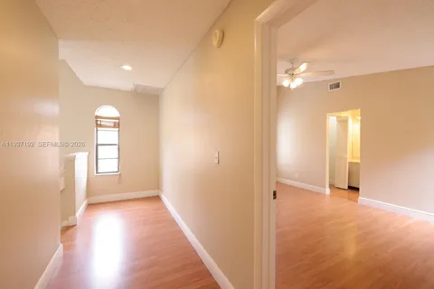 a view of hallway with windows and wooden floor
