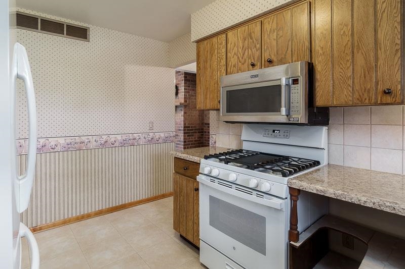2369 South Lowden Road Oregon, IL 61061 - Photo 24 of 51 a kitchen with granite countertop wooden cabinets and a stove top oven