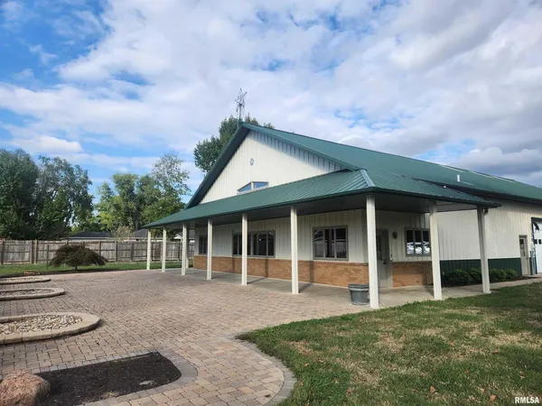 a view of a house with a yard and a large tree