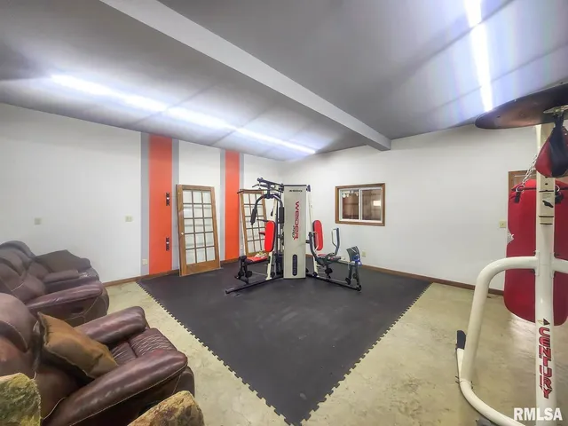 a living room with furniture gym equipment and a large window